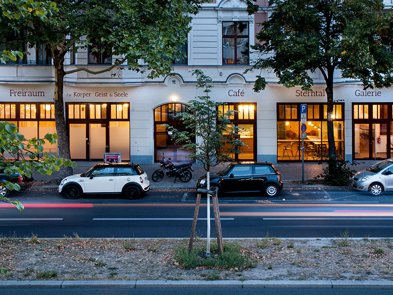 Sterntal Rheinstrase parkende Autos und beleuchtetes Cafe im Erdgeschoss